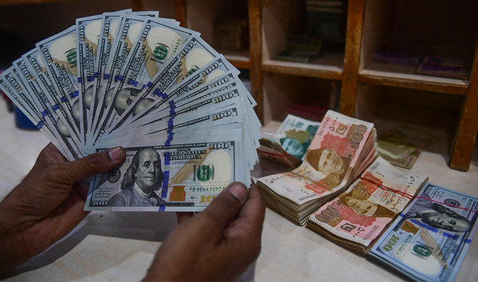 A foreign currency dealer counts US dollars at a shop in Karachi on May 19, 2022. (AFP/File)