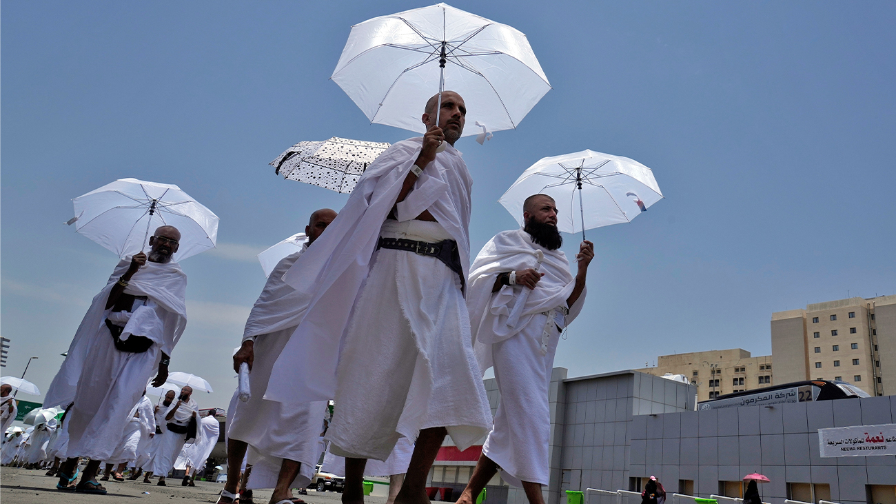 Muslim pilgrims walk, holding their umbrellas at the Mina tent camp, in Mecca, Saudi Arabia, during the annual hajj pilgrimage, on June 26, 2023. (AP)