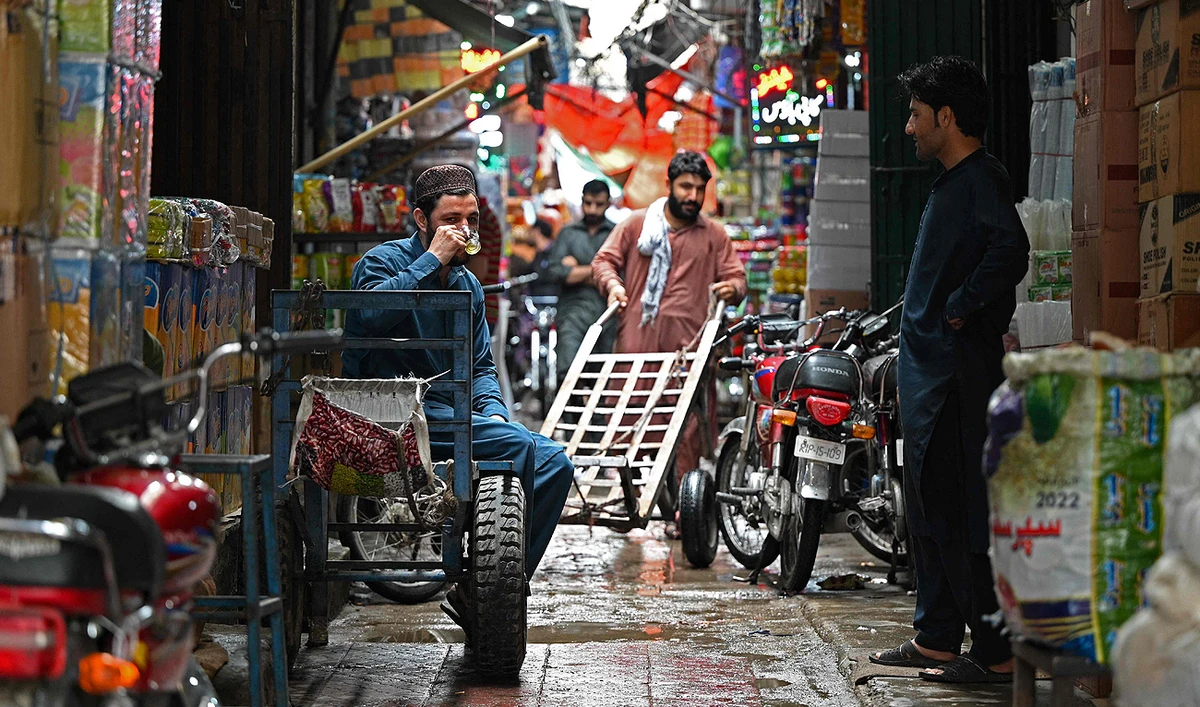 A trader drinks tea along an alley in a market in Rawalpindi on June 1, 2023. (Photo courtesy: AFP)