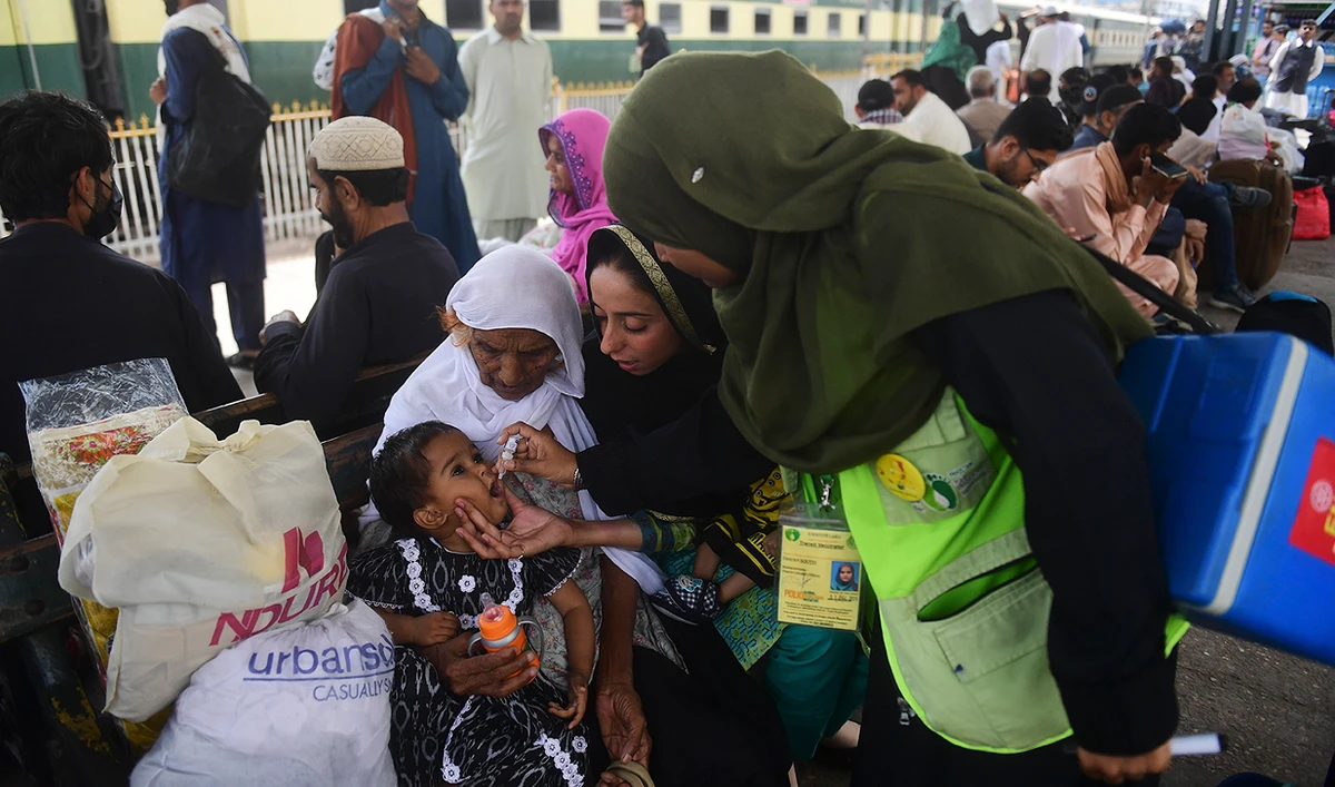 A health worker administers polio vaccine drops to a child at a railway station during a vaccination campaign in Karachi on March 14, 2023. (Photo courtesy: AFP)
