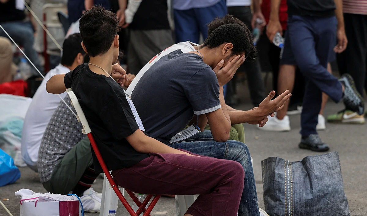 Migrants, survivors of a deadly shipwreck after a boat capsized at open sea off Greece, wait to board a bus as they are being transferred to Athens from the port of Kalamata, Greece, June 16, 2023. (REUTERS)