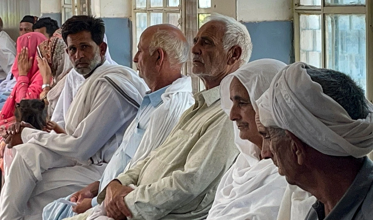 Relatives of migrants, who went missing after an overloaded trawler capsized and sank in the Ionian Sea, wait to provide DNA samples at a hospital in Bandli village, Azad Kashmir on June 20, 2023. (AFP)