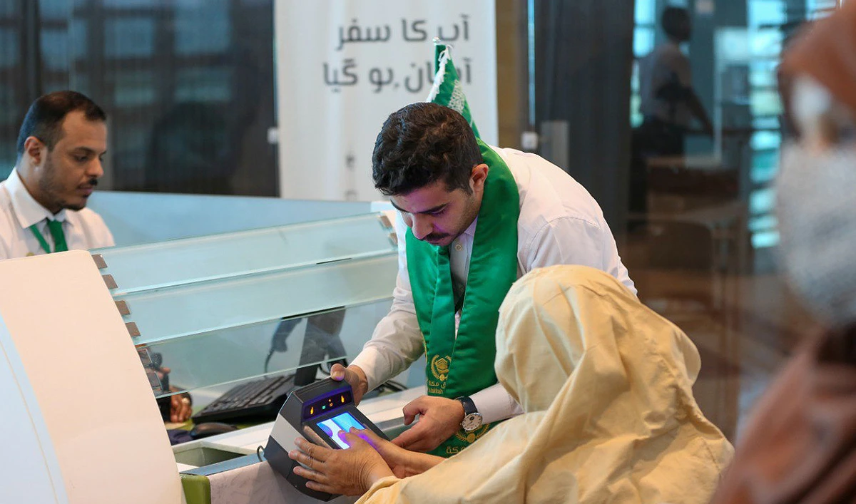 Saudi official facilitates Pakistani Hajj pilgrim during biometrics at the immigration counter at the Islamabad International Airport on June 13, 2023. (Photo courtesy: Twitter/MakkahRoute)