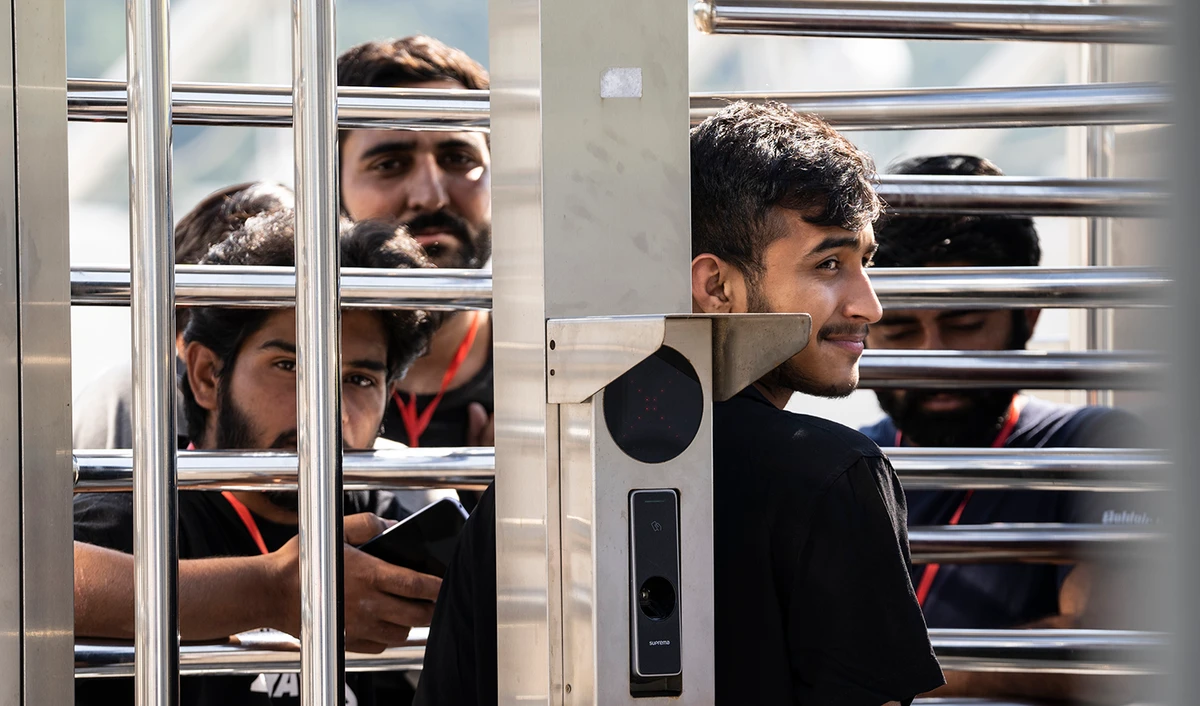 A man waits at the turnstiles and speaks with survivors of a deadly migrant boat sinking at a migrant camp in Malakasa north of Athens, on June 19, 2023. (AP)