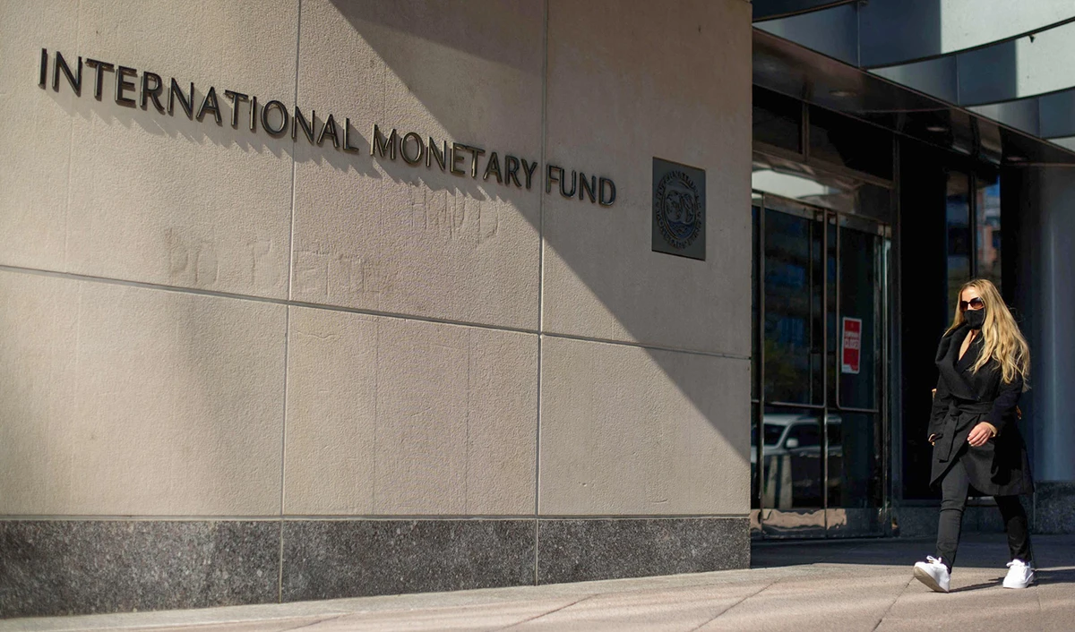 A woman passing by International Monetary Fund (IMF) headquarters in Washington DC, United States on April 5, 2021. (AFP/File)