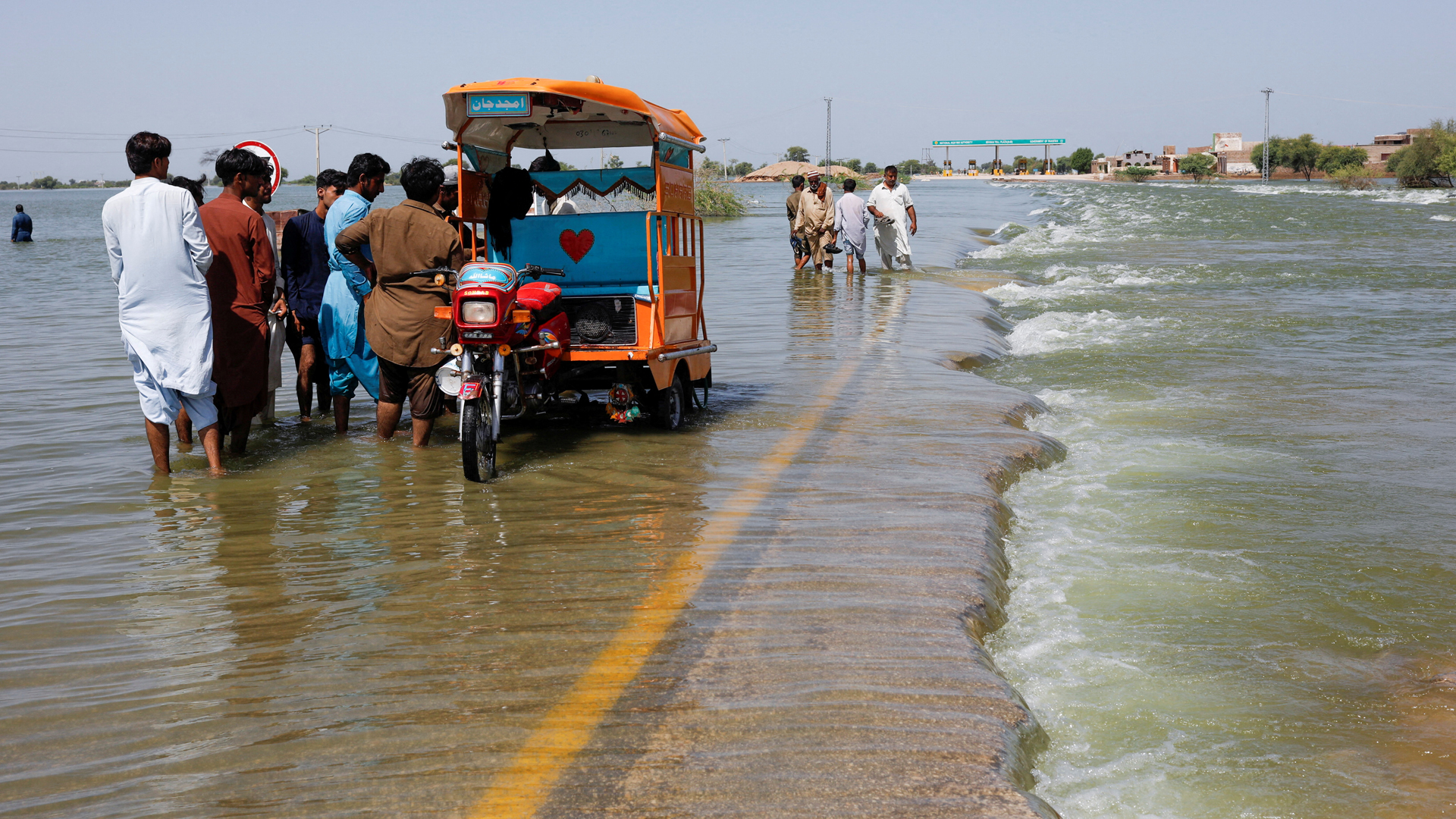 In this file photo, taken on September 16, 2022, displaced people stand on flooded highway, following rains and floods during the monsoon season in Sehwan, Pakistan. (REUTERS/File)