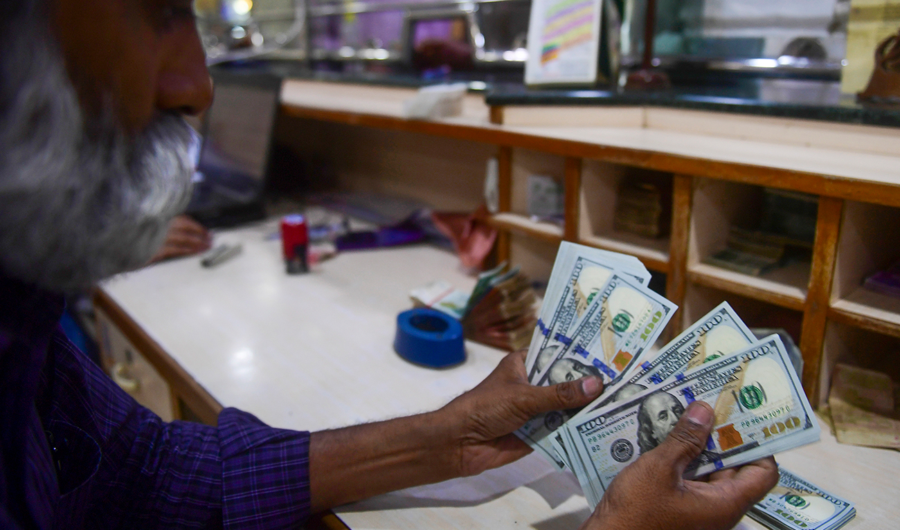 A foreign currency dealer counts US dollars at a shop in Karachi on May 19, 2022. (AFP/File)