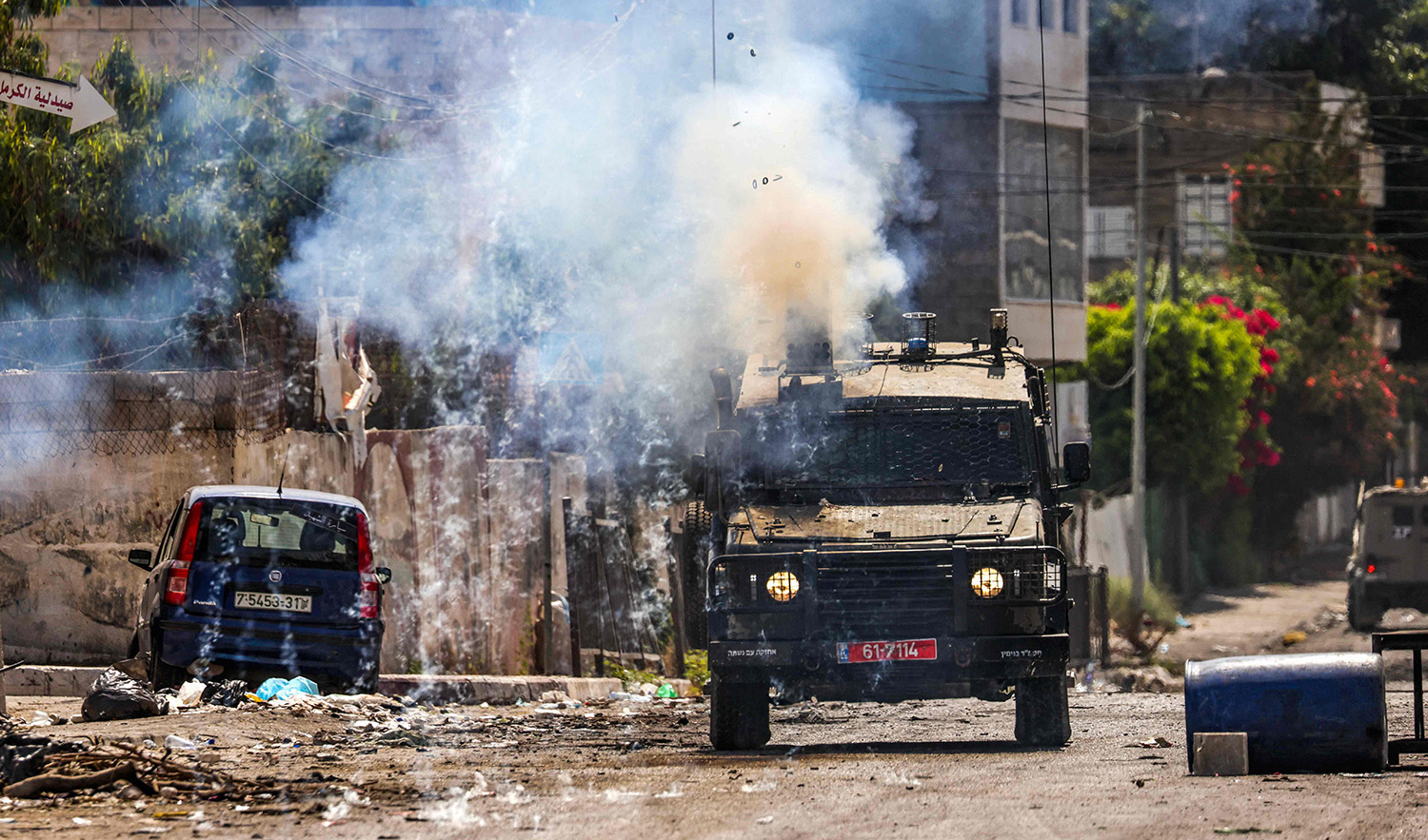 Israeli soldiers fire tear gas canisters from an armoured vehicle during an ongoing military operation in the occupied West Bank city of Jenin on July 4, 2023. (AFP)