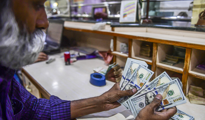 A foreign currency dealer counts US dollars at a shop in Karachi, Pakistan, on May 19, 2022. (AFP/File)