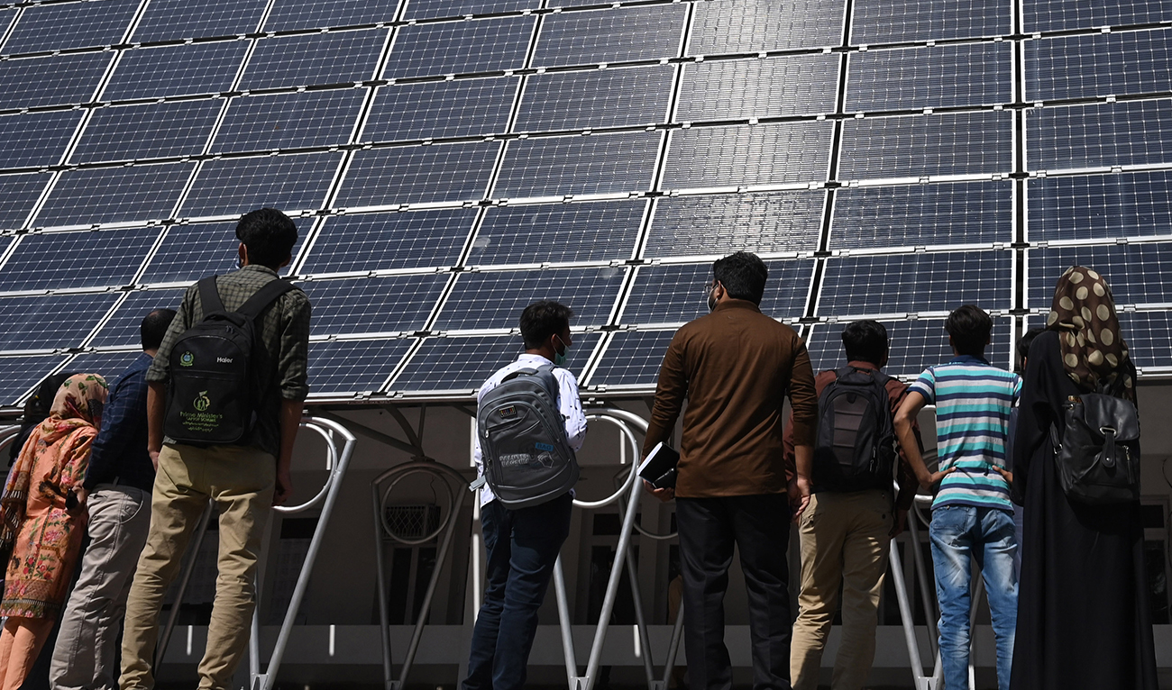 Students look at the facade of a building made with solar panels producing some 148 Kilowatts during its inauguration at the University of Engineering and Technology in Lahore on October 12, 2020. (AFP/File)