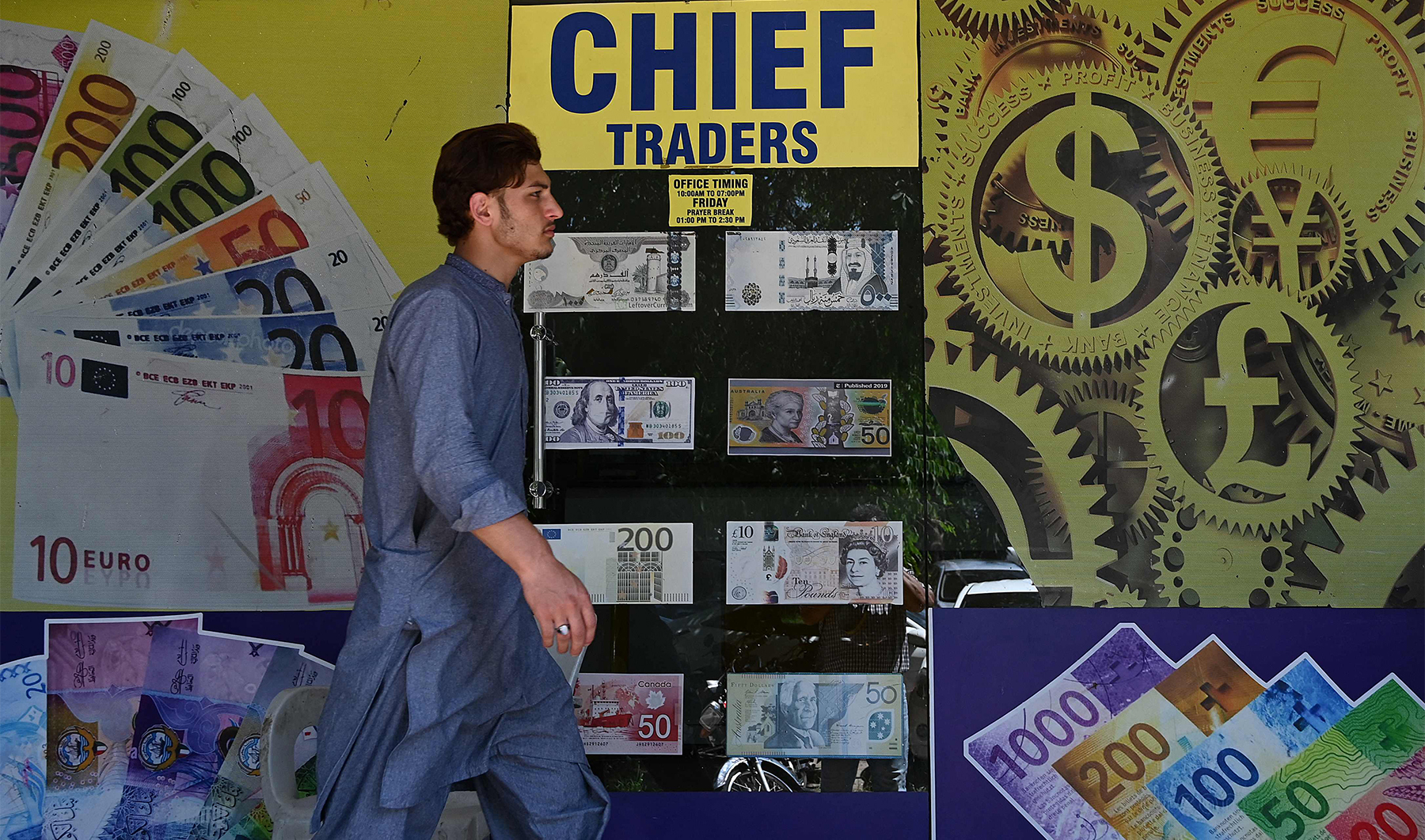 A man walks past a foreign currency exchange market in Islamabad, Pakistan, on July 11, 2023. (AFP/File)
