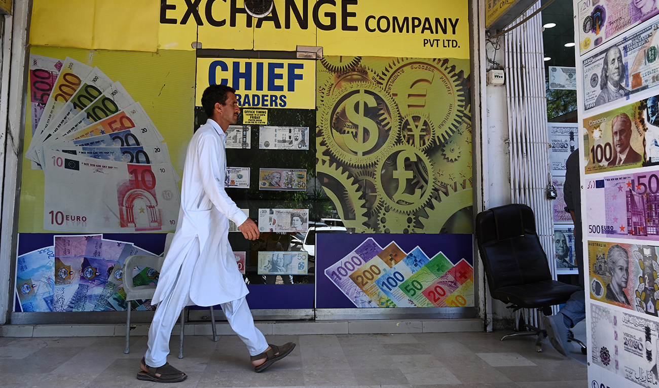 A man walks past foreign currency exchange market in Islamabad on July 11, 2023. (AFP/File)