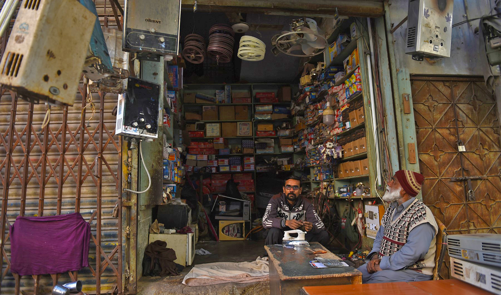 A shopkeeper sits inside his electronic repairing shop in Karachi, Pakistan, on January 10, 2021. (AFP/File)