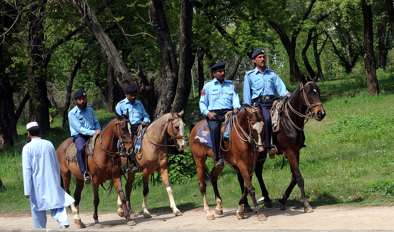 In this file photo, taken on April 10, 2009, Pakistani policemen patrol on horses along a street near Margalla Hill in Islamabad. (AFP/File)