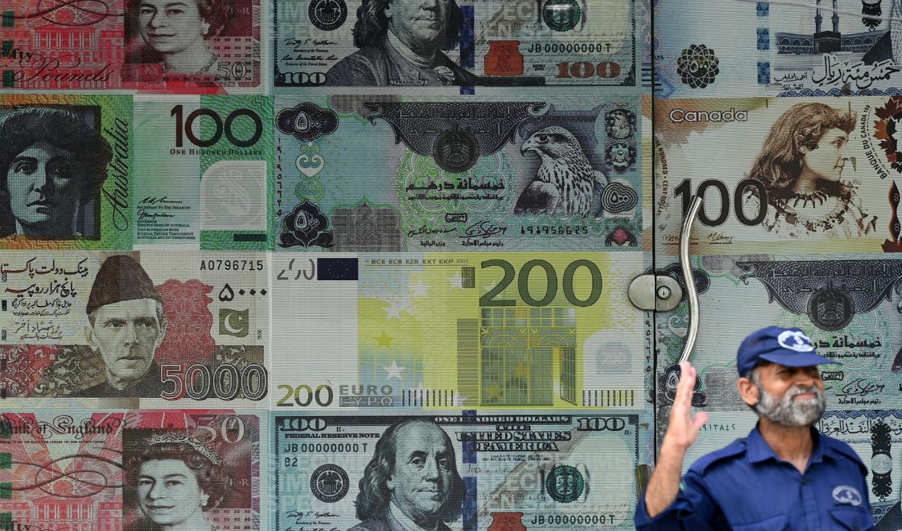 A security guard stands outside a currency exchange shop in Rawalpindi on July 15, 2023. (AFP/File)