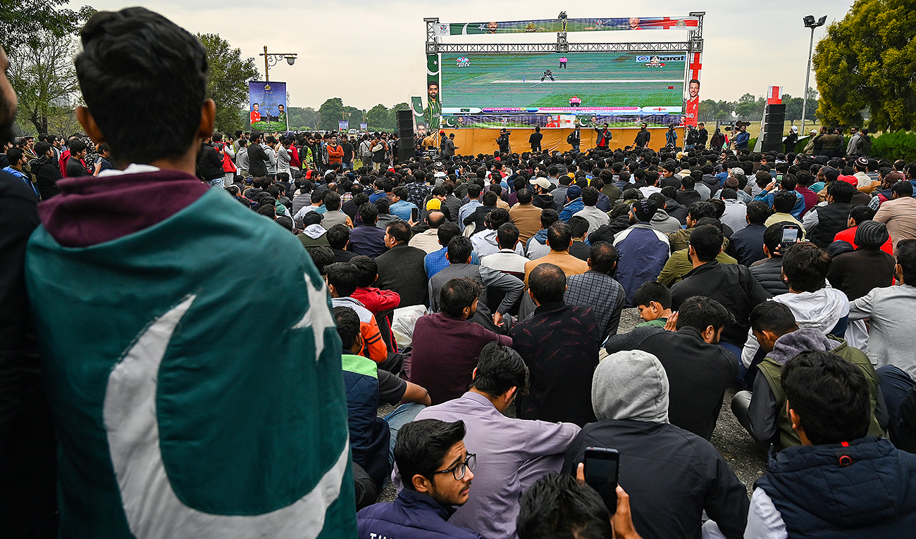 In this picture, taken on November 13, 2022, cricket fans react as they watch the ICC men's Twenty20 World Cup 2022 final cricket match between Pakistan and England, on a big screen at a park in Islamabad. (AFP/File)