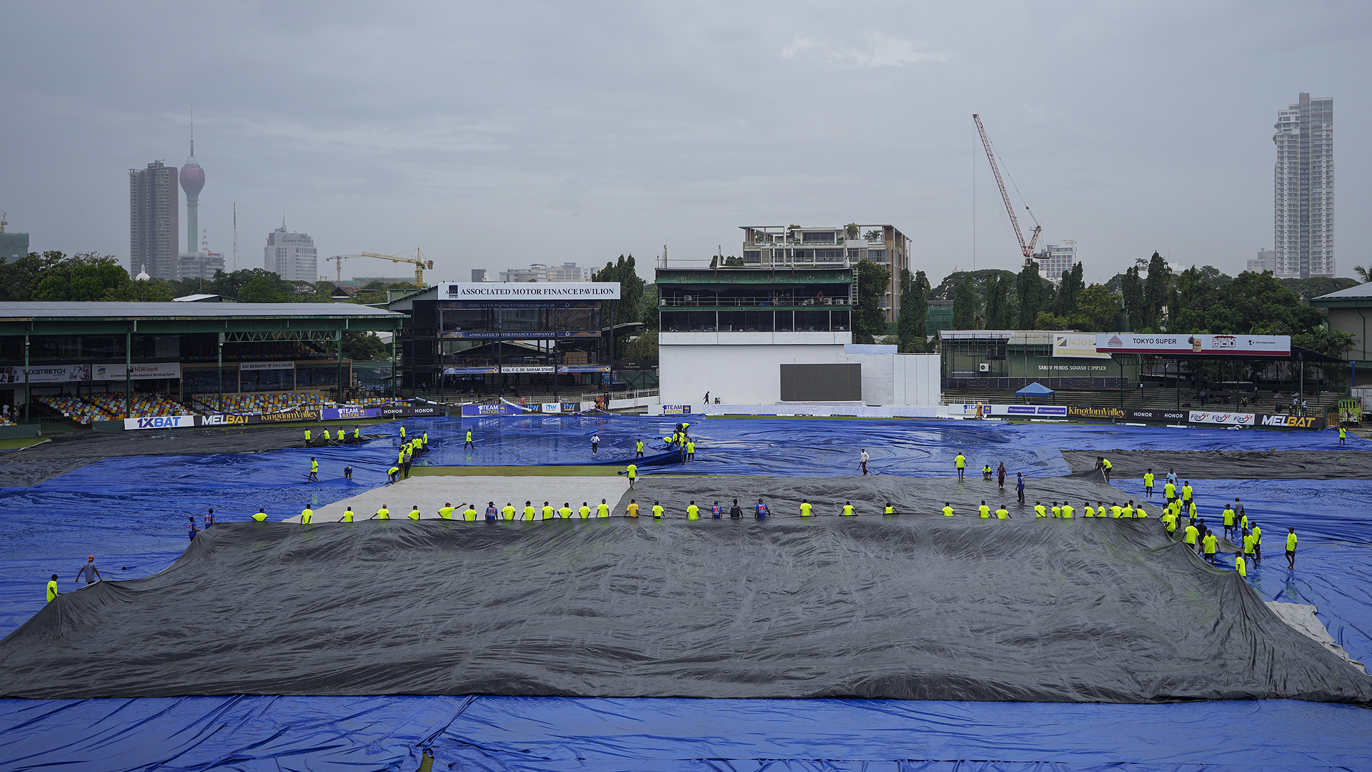 Ground staff cover the filed as it rains during the second day of the second cricket test match between Sri Lanka and Pakistan in Colombo, Sri Lanka on July 25, 2023 (AP)