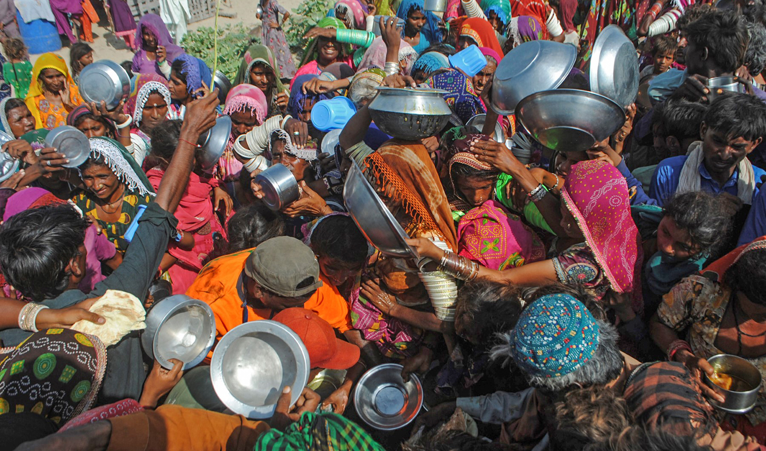 Internally displaced people gather to receive free food near their makeshift camp in the flood-hit Chachro of Pakistan's Sindh province on September 19, 2022. (AFP/File)