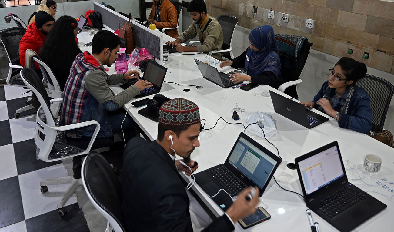 In this picture taken on January 8, 2022, employees of call centre speak with clients in Lahore, Pakistan. (AFP/File)