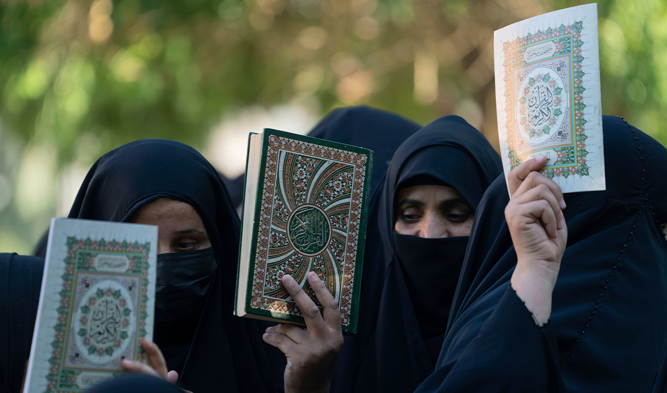 Iraqis raise copies of the holy Qur’an during a protest in Baghdad, Iraq, on July 22, 2023. (AP)