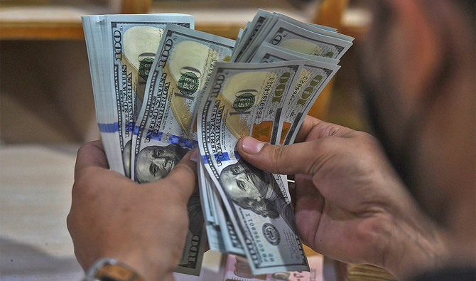 A foreign currency dealer counts US dollar notes at a shop in Karachi, Pakistan, on January 11, 2022. (AFP/File)