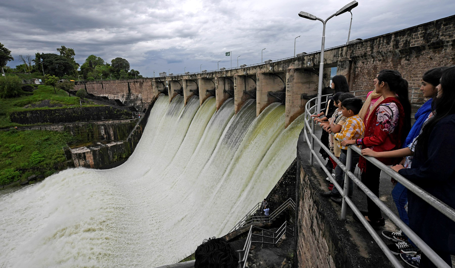 People watch the Rawal Dam after the spillway opened due to heavy monsoon rains, in Islamabad, Pakistan, on August 31, 2020. (AFP/File)