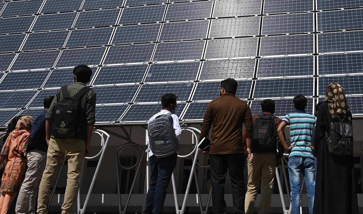 Students look at the facade of a building made with solar panels producing some 148 Kilowatts during its inauguration at the University of Engineering and Technology in Lahore on October 12, 2020. (AFP/File)
