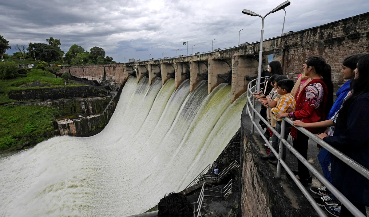 People watch the Rawal Dam after the spillway opened due to heavy monsoon rains, in Islamabad, Pakistan, on August 31, 2020. (AFP/File)