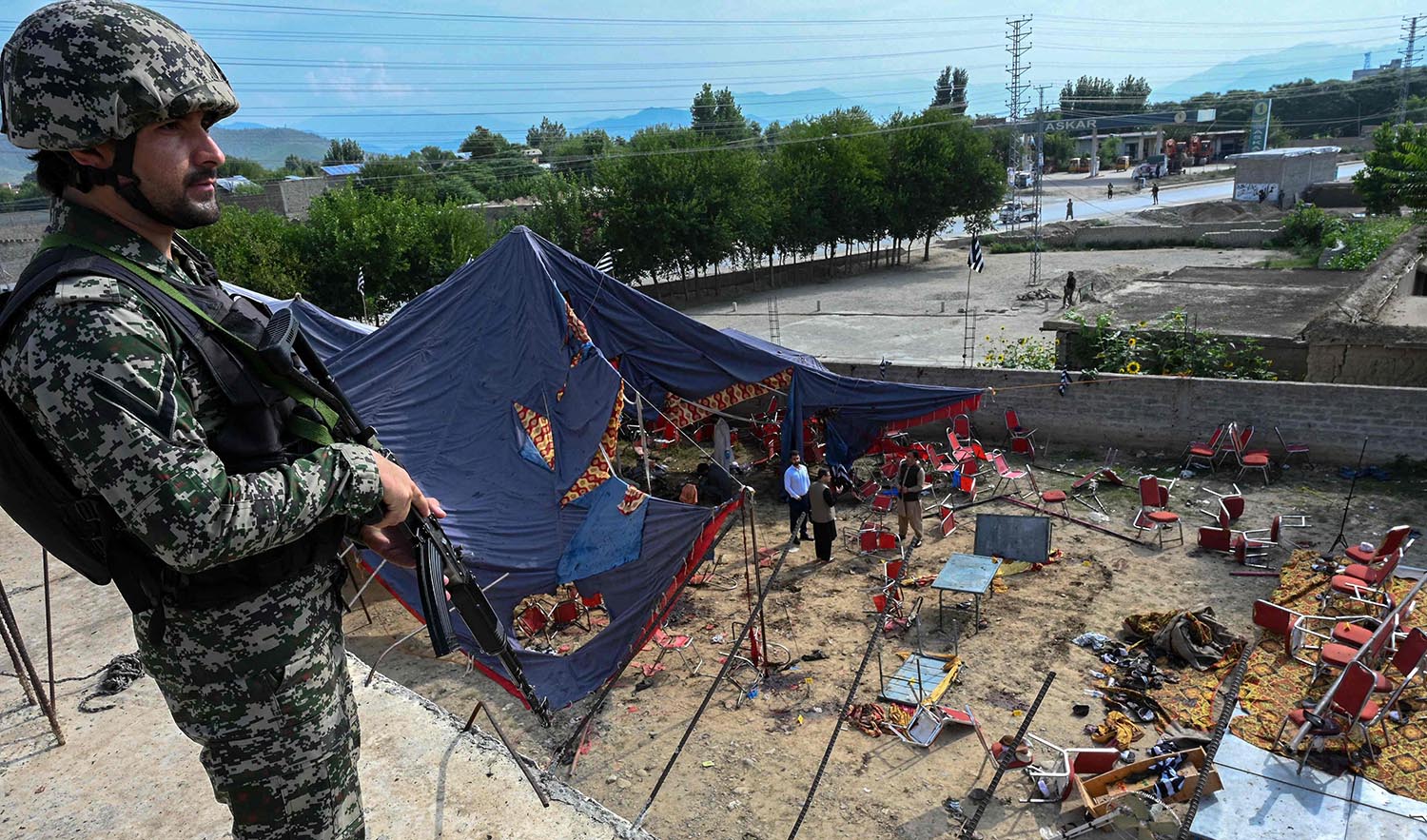 A security personnel stands guard next to the site of a bomb blast in Bajaur district of Pakistan's Khyber-Pakhtunkhwa province on July 31, 2023. (AFP)