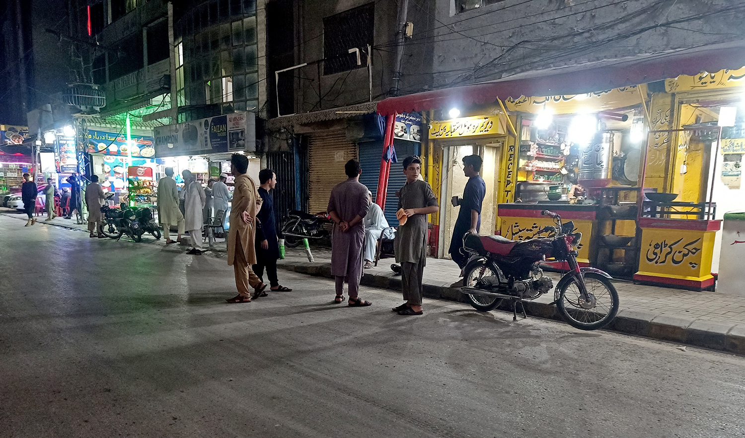 People stand in the street after they vacated eateries following an earthquake in Peshawar, Pakistan, on August 5, 2023. (REUTERS)