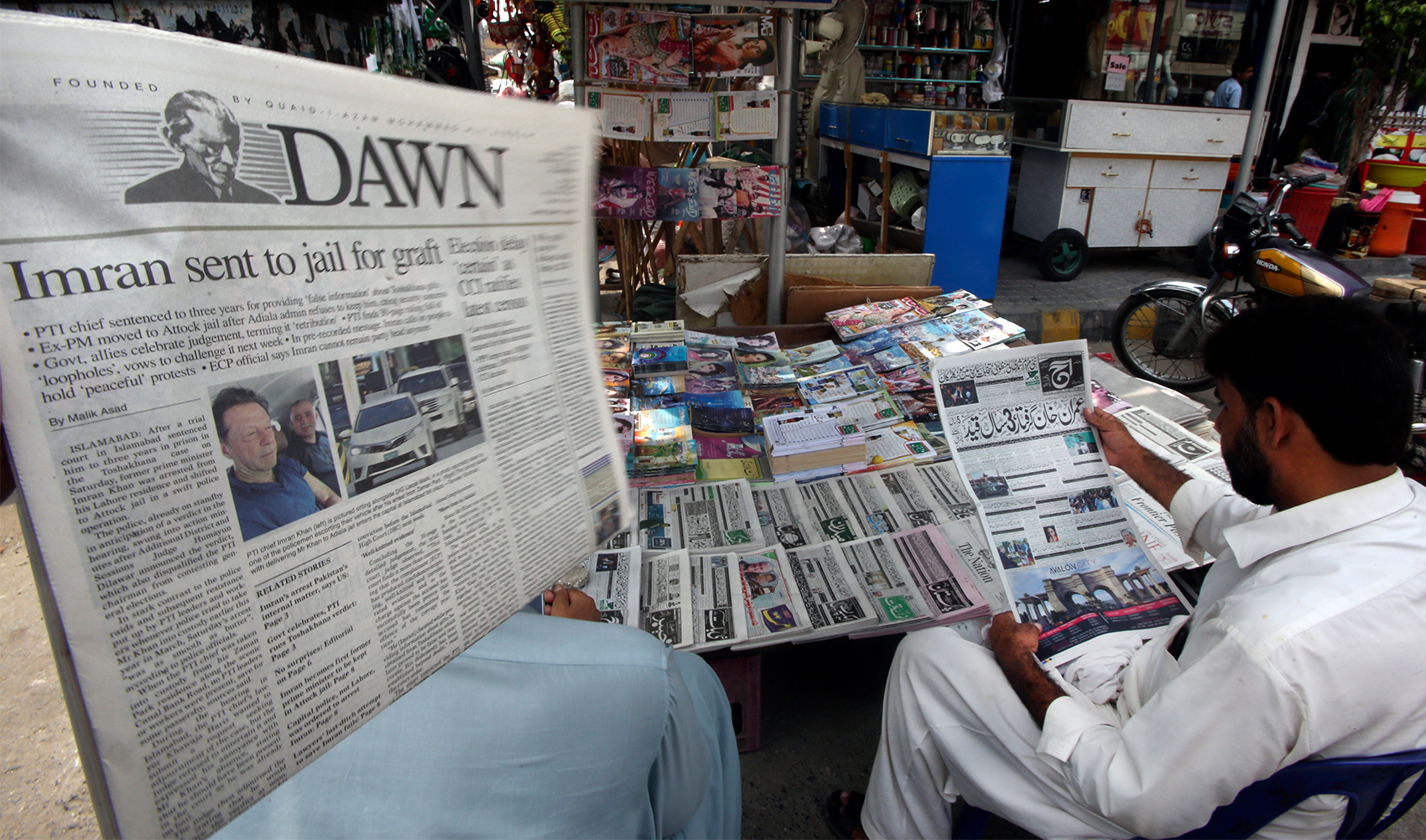 A man reads a local newspaper with photos of Pakistan's former Prime Minister Imran Khan, in Peshawar, Pakistan, on August 6, 2023. (AP)