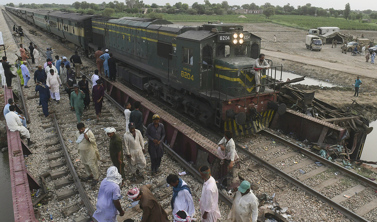 Railway workers repaire the tracks next to damaged carriages a day after the derailment of a passenger train in NawabShah on August 7, 2023. (AFP)