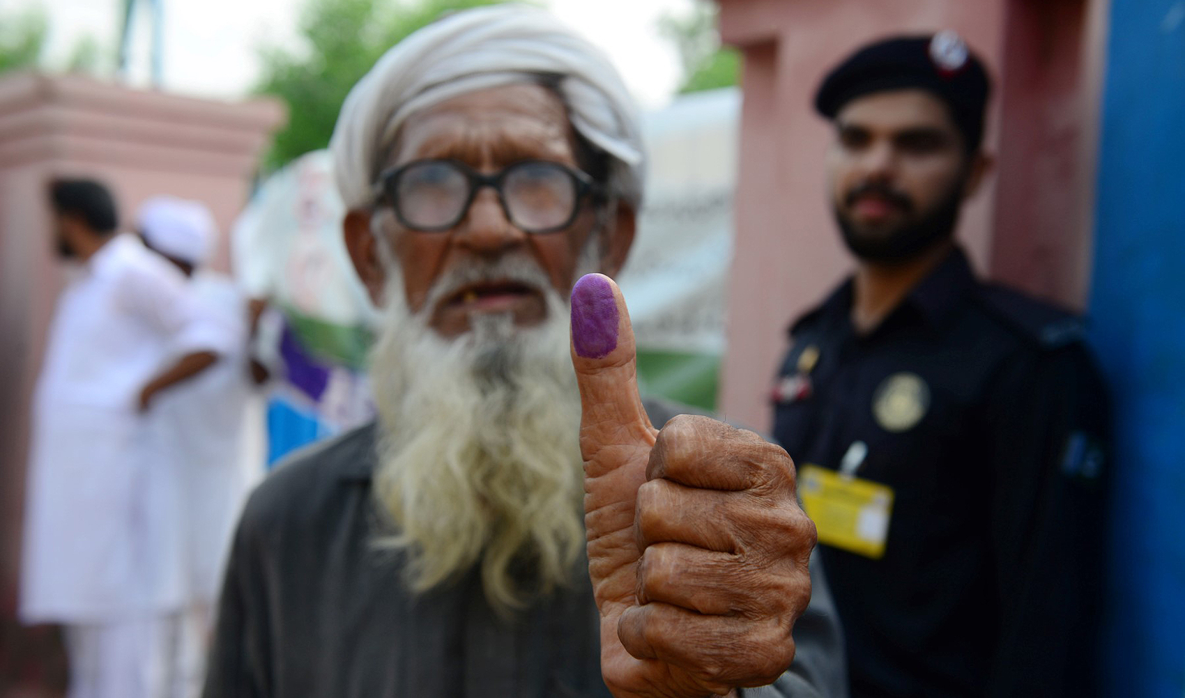 An elderly Pakistani man shows his inked thump after casting his vote outside a polling station during general election in Lahore, Pakistan, on July 25, 2018. (AFP/File)