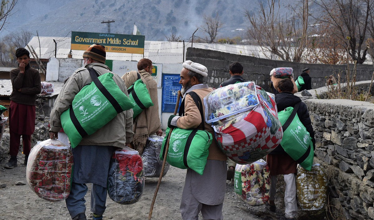 In this handout picture released by King Salman Humanitarian Aid and Relief (KSrelief) on December 14, 2022, elderly men can be seen carrying winter relief packages in the northern areas of Pakistan. (Photo courtesy: KSrelief/File)