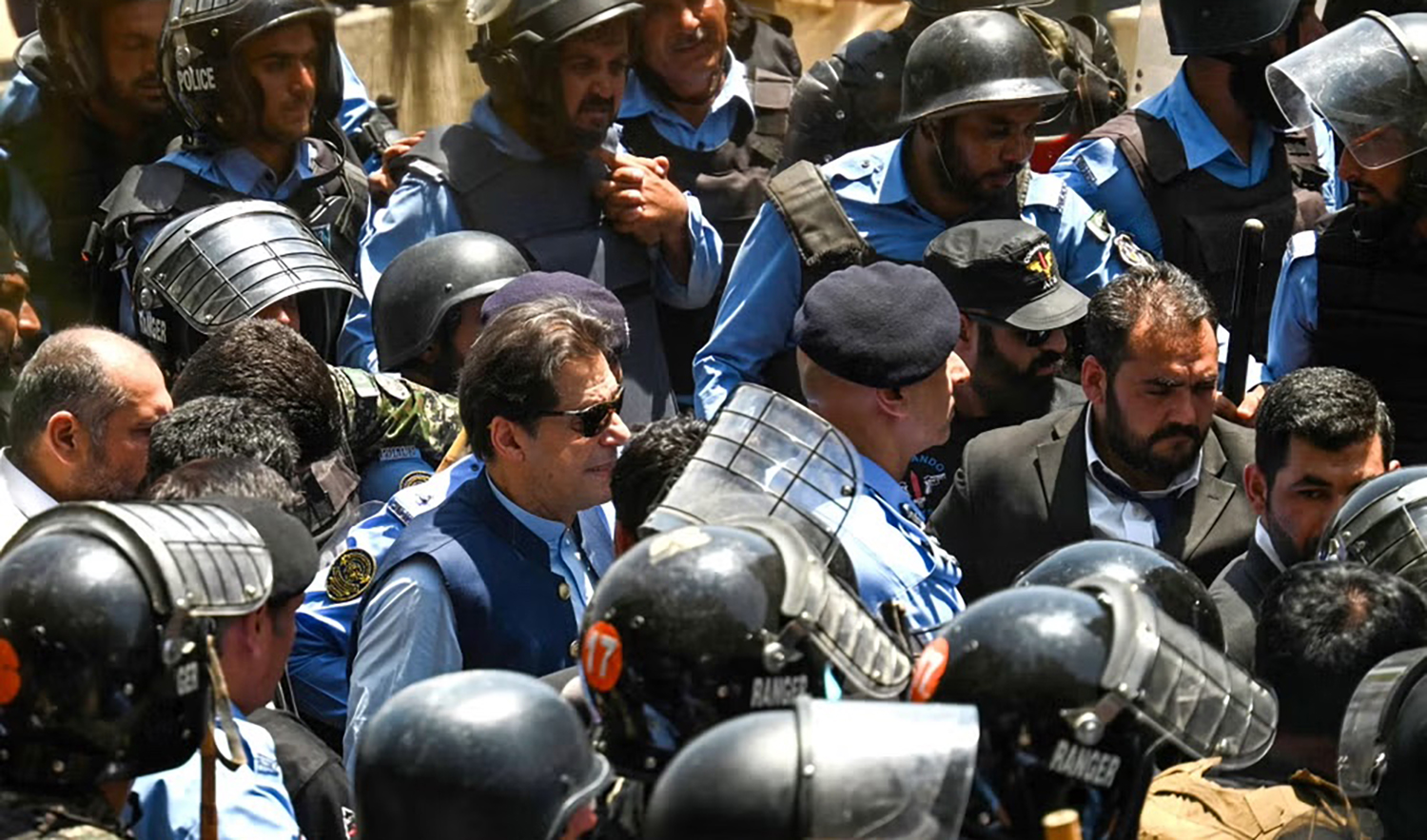 Policemen escort Pakistan's former Prime Minister Imran Khan, center, as he arrives at the high court in Islamabad on May 12, 2023. (AFP/File)