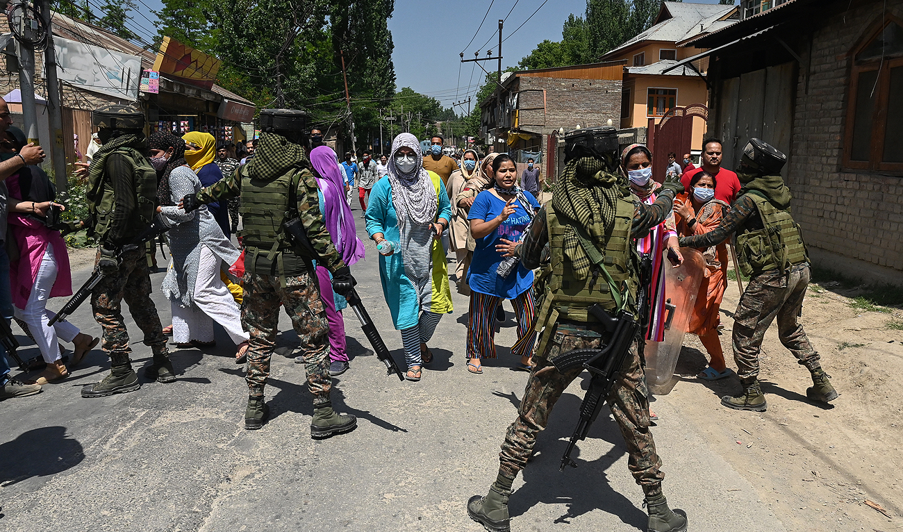 Members of Indian security personnel stop demonstrators from marching toward the governor's house to protest on the outskirts of Srinagar on May 13, 2022. (AFP/File)