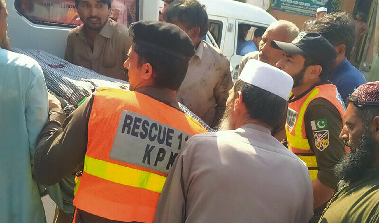 This handout photograph taken and released by Pakistan's Emergency Rescue 1122 Service on August 26, 2023 shows rescue workers shifting victim's body to ambulance after an accident in northwestern Khyber Pakhtunkhwa province. (Photo courtesy: Rescue 1122)