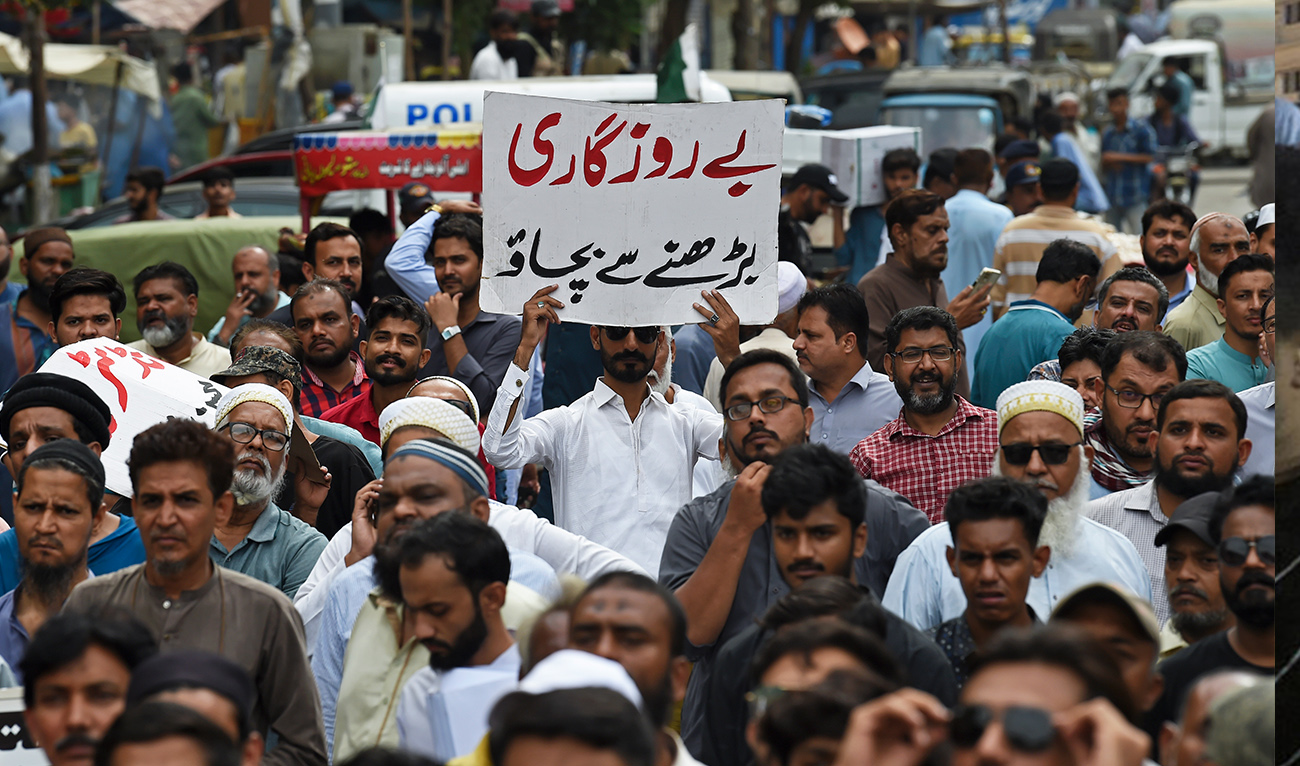 A trader holds a placard reading 'prevent unemployment from rising' during a protest at a street in Karachi on August 23, 2023, against the surge in petrol and electricity prices as Pakistan endures soaring inflation. (Photo courtesy: AFP)