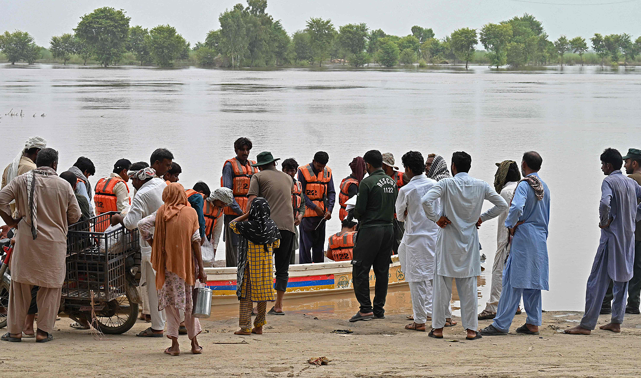 Rescue personnel evacuate people on a boat from a flooded village in the Okara district of Punjab province on August 28, 2023. (AFP)