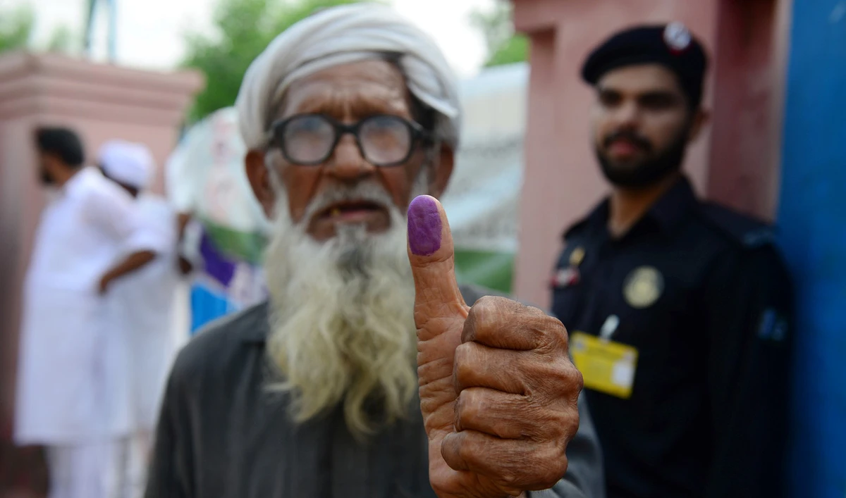 An elderly Pakistani man shows his inked thump after casting his vote outside a polling station during general election in Lahore, Pakistan, on July 25, 2018. (AFP/File)