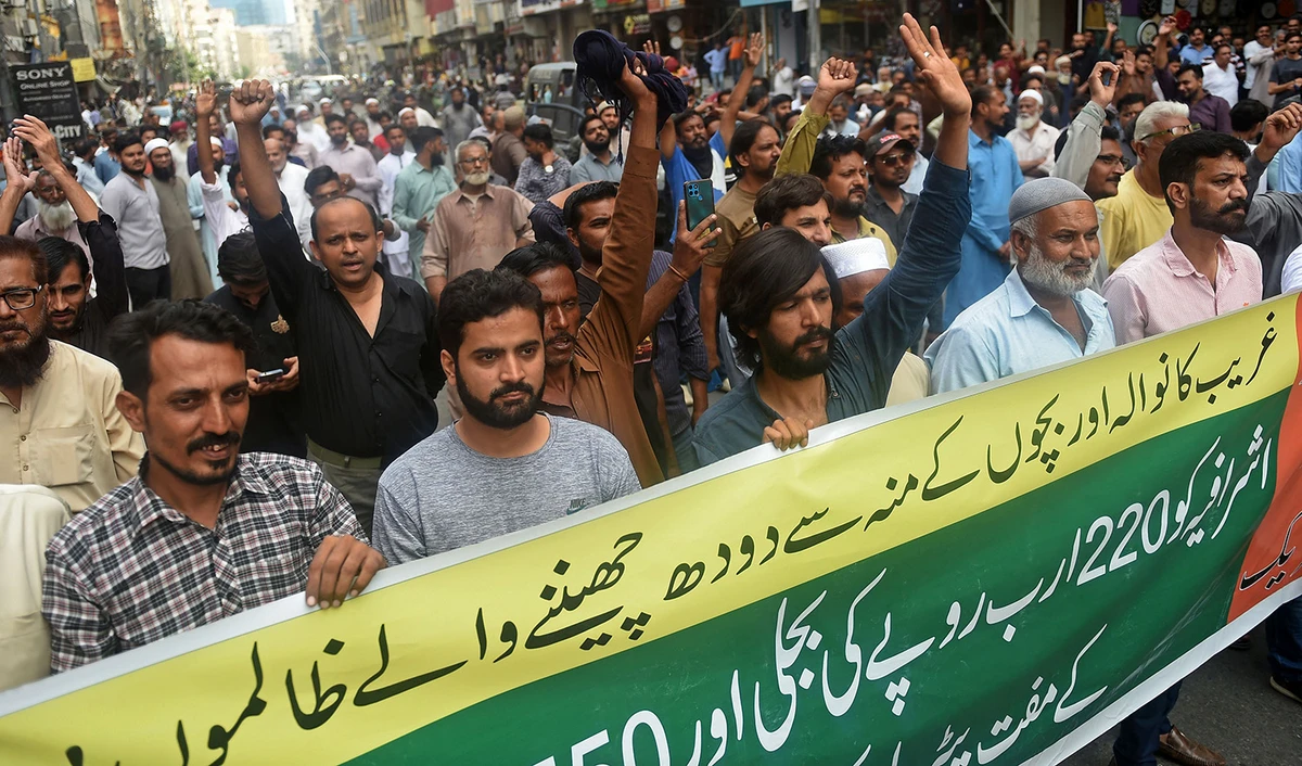 Traders shout slogans while holding a banner during a protest at a street in Karachi on August 28, 2023, against the surge in petrol and electricity prices. (AFP)