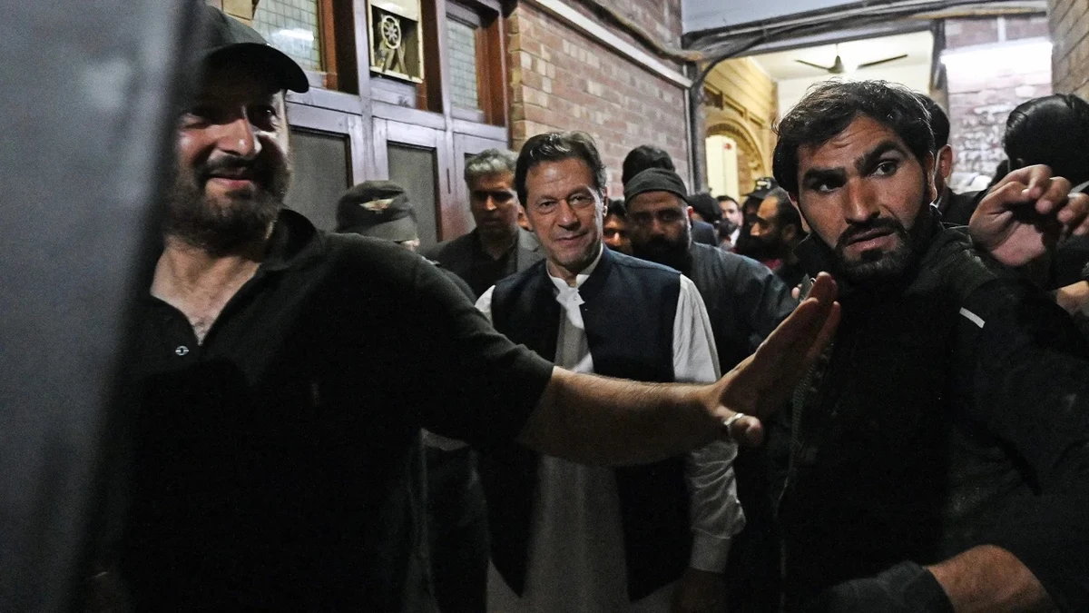 Security personnel use a bullet proof shield to protect former Pakistan's Prime Minister Imran Khan as he leaves after appearing at the high court in Lahore on March 17, 2023. (AFP/File)