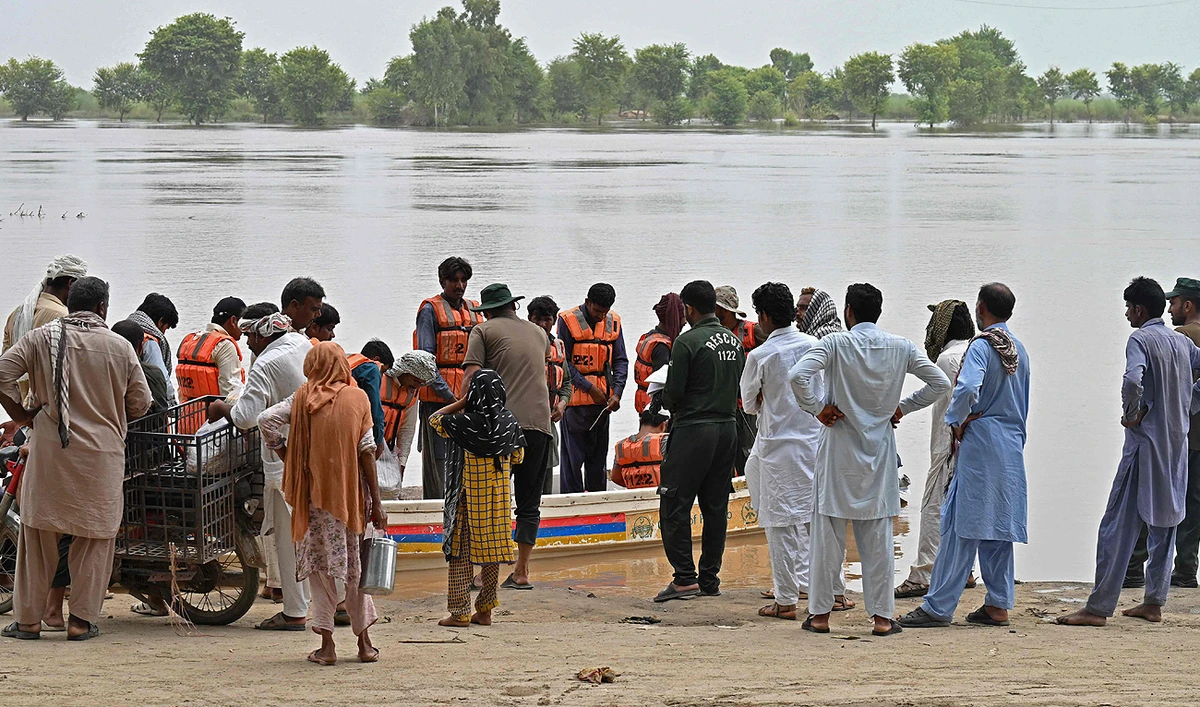 Rescue personnel evacuate people on a boat from a flooded village in the Okara district of Punjab province on August 28, 2023. (AFP)