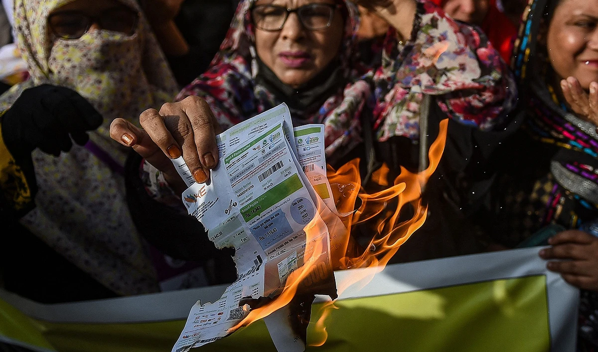 Women activists of Pakistan's Jamat-e-Islami party set electricity bills on fire during a protest against the surge in electricity prices along a street in Karachi on August 31, 2023. (AFP)