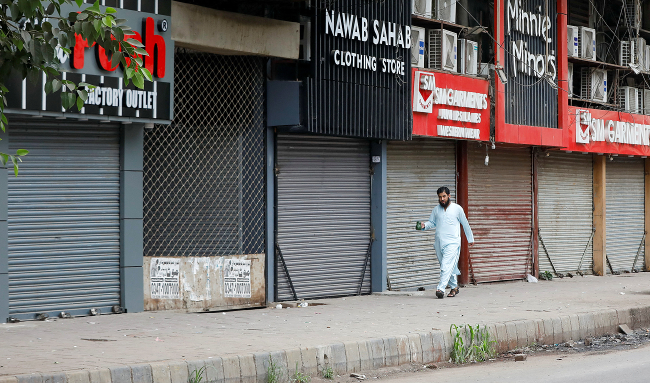 A man walks with a tea kettle along closed market, during a shutter down strike called by the traders, against the hikes in power billings, during a protest in Karachi, Pakistan September 1, 2023. (REUTERS)