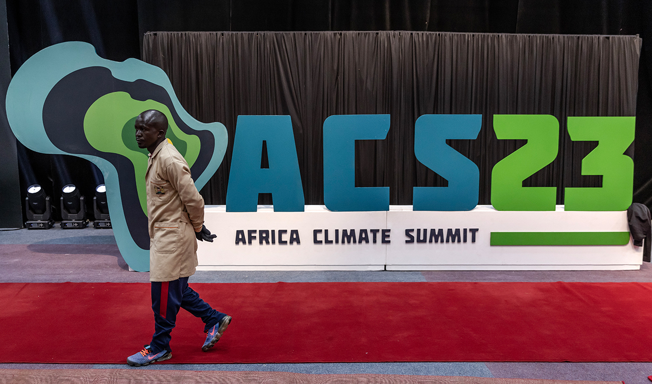 A worker walks past an Africa Climate Summit logo during preparations ahead of the Africa Climate Summit 2023 at the Kenyatta International Convention Centre in Nairobi, Kenya on September 2, 2023. (AFP)