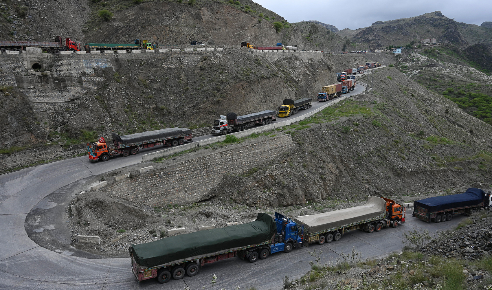A general view shows trucks parked along a road after a landside blocked the road near Pakistan's Torkham border town on April 18, 2023. (Photo courtesy: AFP/File)