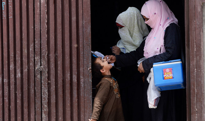 A Pakistani health worker administers polio vaccine drops to an Afghan refugee child during a polio vaccination campaign in Lahore on June 19, 2019. (AFP/File)