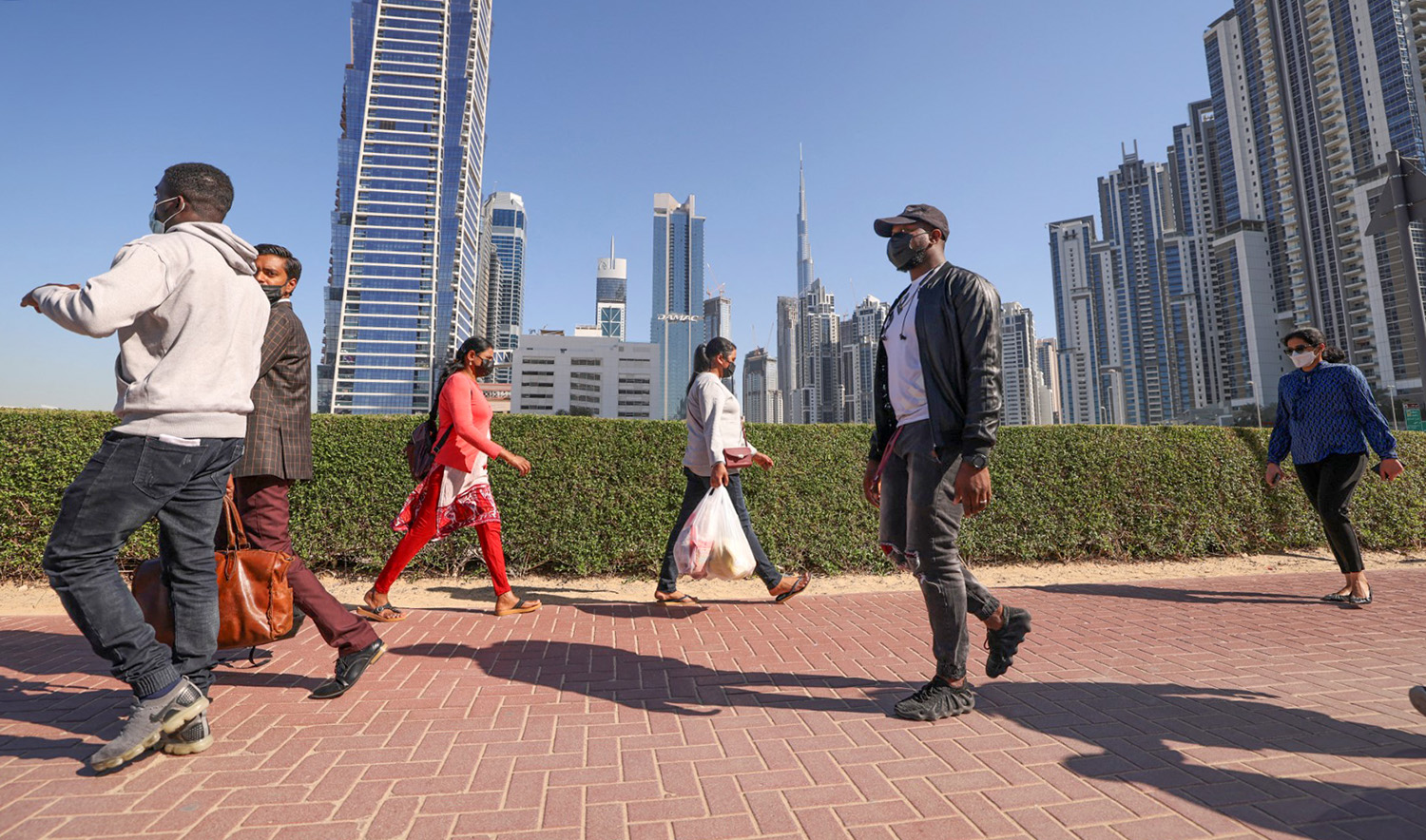 Employees walk to work on the first working Friday in the Gulf Emirate of Dubai, on January 7, 2022. (AFP/File)