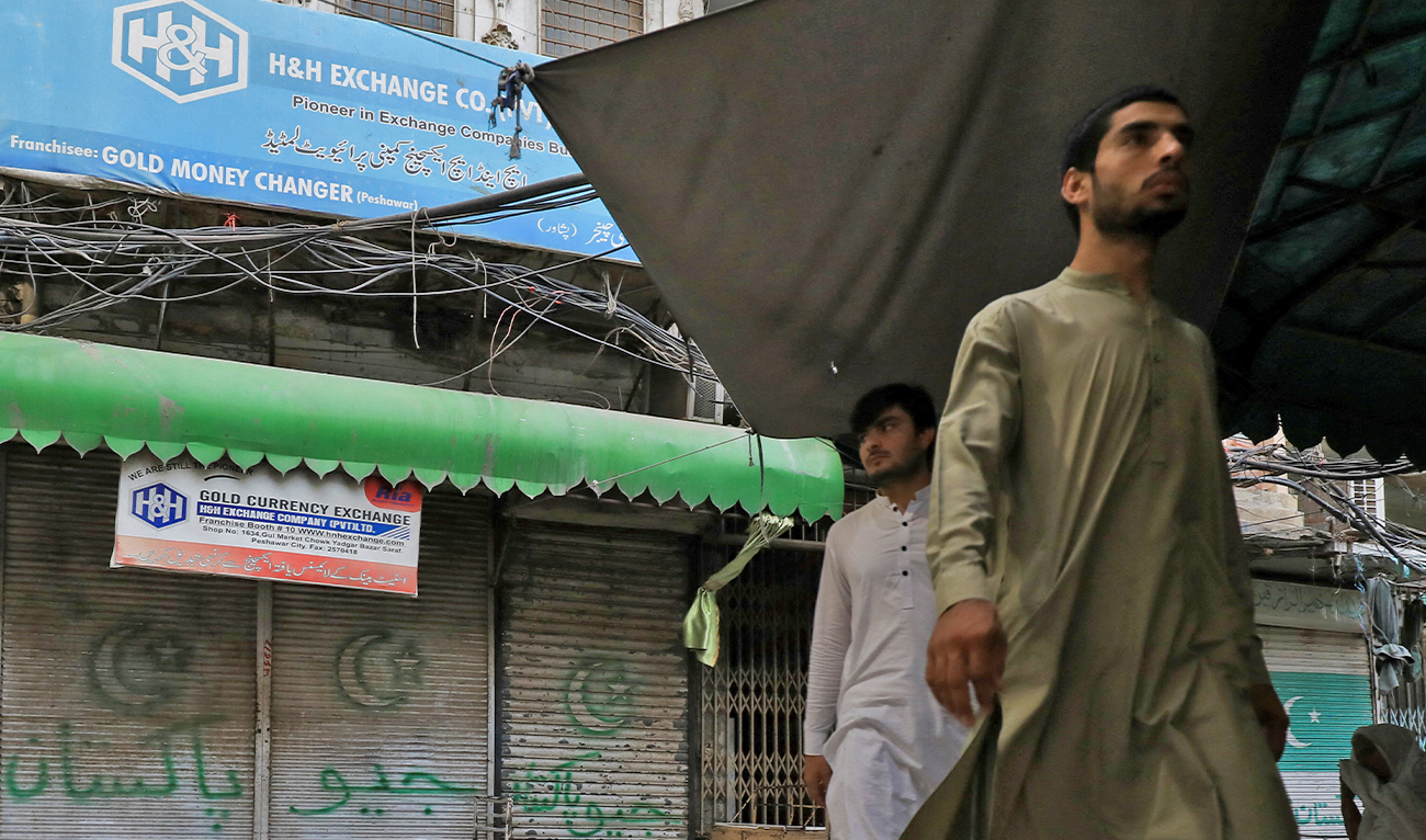People walk along closed foreign exchange shops, in Peshawar, Pakistan on September 7, 2023. (Photo courtesy: REUTERS/File)